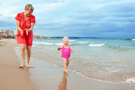 幸福的母亲和他的小女儿在海滩上