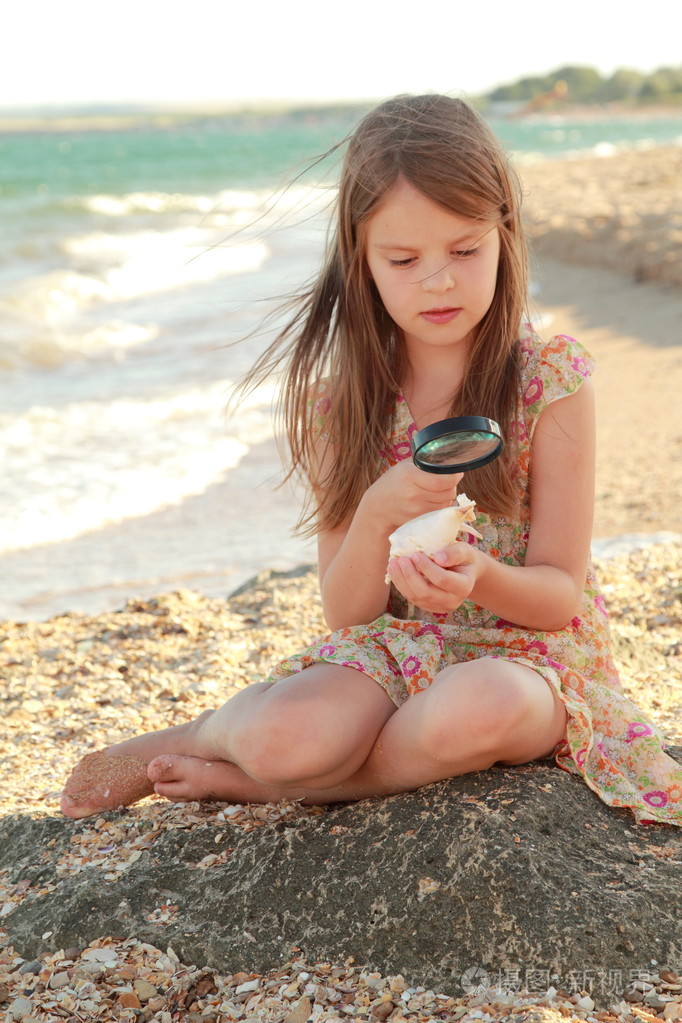 可爱的女孩与一个美丽的笑容打赤脚在海滩上水