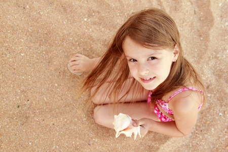 可爱的小女孩用贝壳的肖像图片