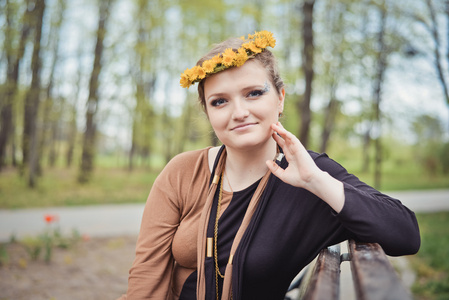 女孩与黄色的花朵在她头上的花环