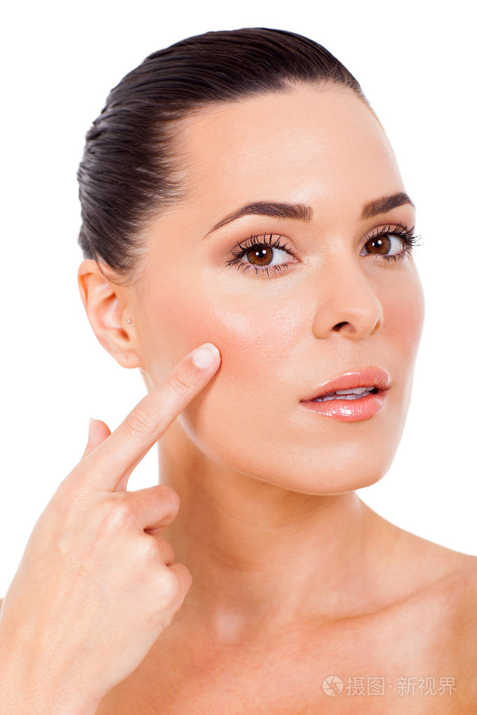 美丽的女人指着她的脸颊
