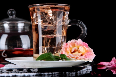 电水壶玻璃杯冰茶从茶玫瑰金属托盘上黑色背景上的餐巾纸上