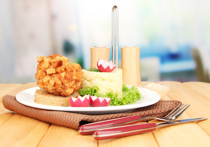 基辅鸡配土豆泥，木桌上，在明亮的背景上的烤面包片上
