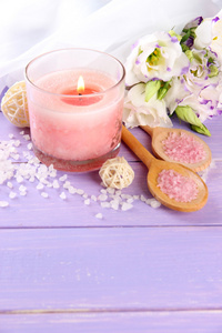 美丽粉红色蜡烛带紫色木制背景上的花朵