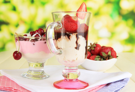 美味的草莓和樱桃点心，在自然背景上的木桌上的玻璃花瓶