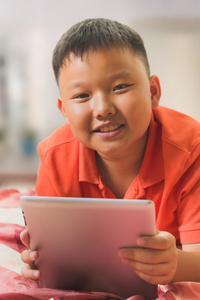 年轻的亚洲男孩与一台平板电脑