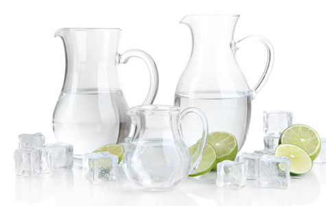 水与冰和孤立在白色的石灰玻璃 pitchers