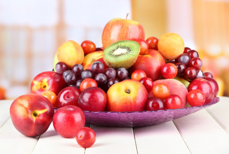 各种各样的木桌上，在明亮的背景上多汁的水果