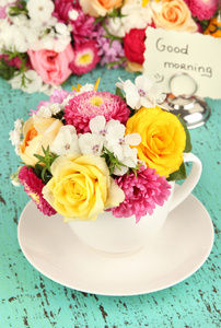 束美丽的鲜艳的花朵在彩色花瓶，在明亮的背景上