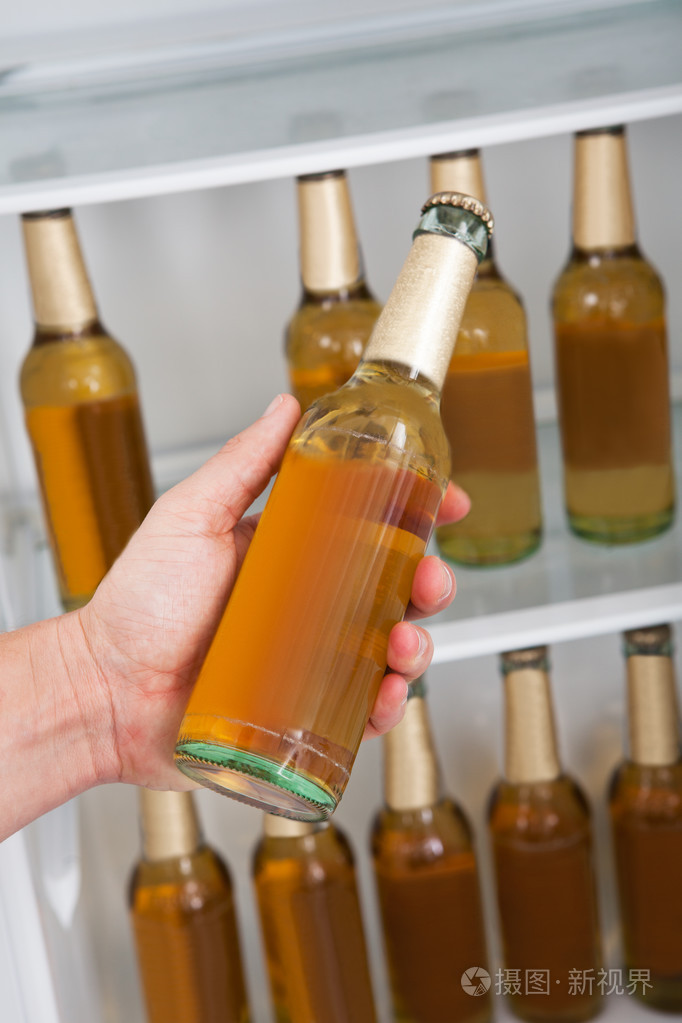 把啤酒从冰箱里的男人