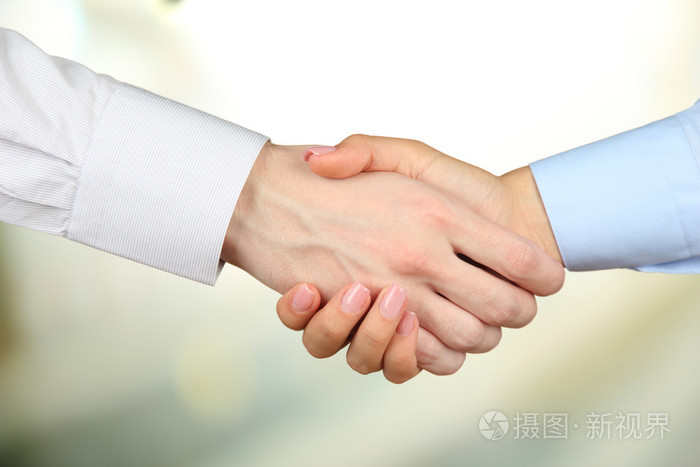 在明亮的背景上商务握手