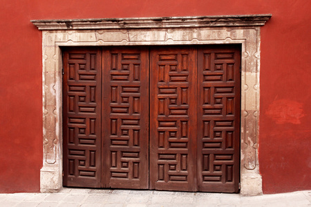 木制装饰门在红墙。墨西哥的体系结构