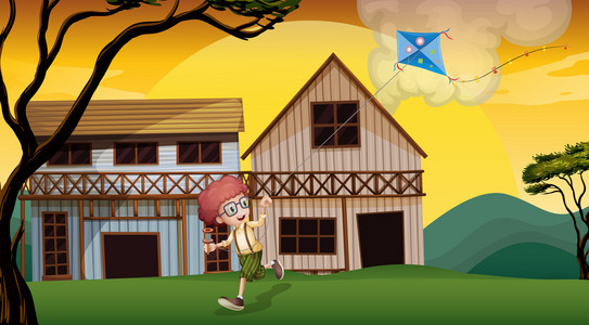 男孩玩他的风筝在木制 barnhouses