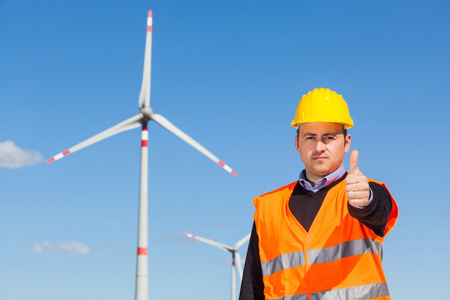 技术员工程师竖起大拇指与风力发电机