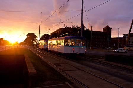 电车在城市的街道上在日落时
