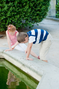 女孩和男孩在喷泉玩耍