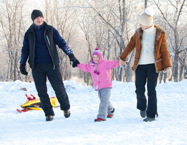 家庭在冬季公园散步