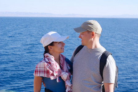 快乐的年轻夫妇外海蓝色海岸的肖像