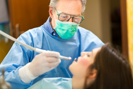 做一名女性患者牙科治疗的牙医图片