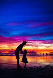 父亲和女儿的剪影在日落在海滩上长滩岛，菲律宾