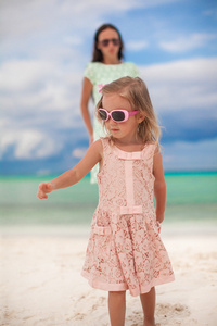 特写小女孩和她年轻的妈妈在白色的沙滩