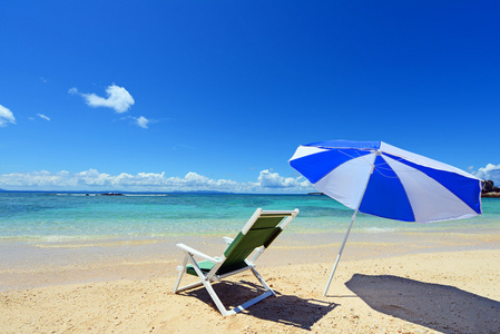 在背景中蓝色的大海与阳光明媚的沙滩上海滩伞