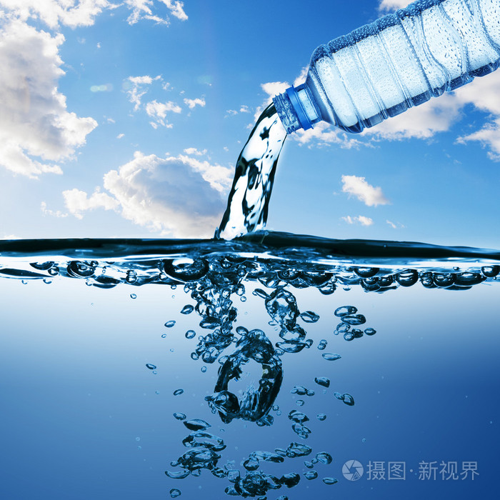 蓝色背景上形成泡沫与水从瓶水