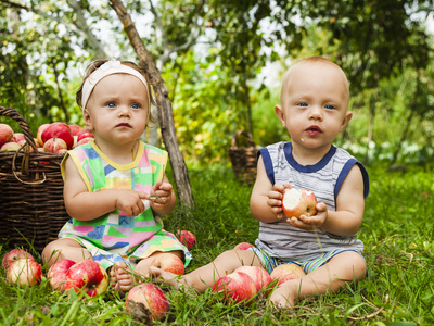 一个小女孩和一个男孩与一篮红苹果