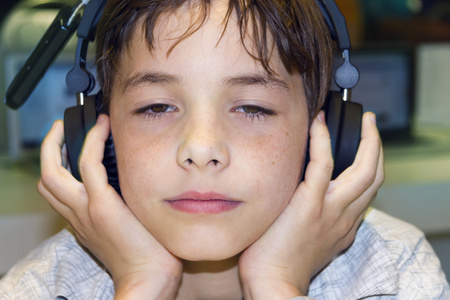 一个甜美的小男孩，听音乐头戴式耳机的肖像