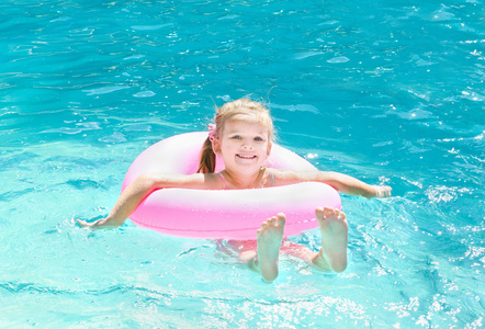 微笑在泳池中的小女孩