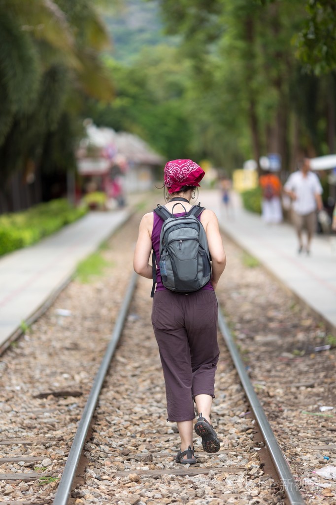 在铁路上行走的女人