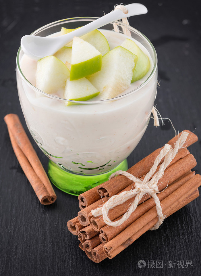 美味酸奶在与苹果和肉桂的玻璃