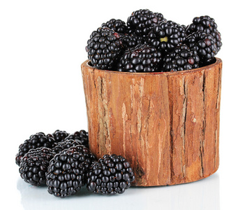 在木制篮子里甜黑莓隔离在白色