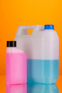 车在橙色背景上毒气罐中的蓝色和粉红色液体