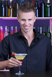 英俊男服务员准备鸡尾酒，在酒吧的肖像