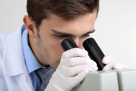年轻的实验室里的科学家在实验室显微镜看