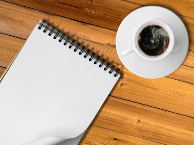 笔记本和白杯热咖啡