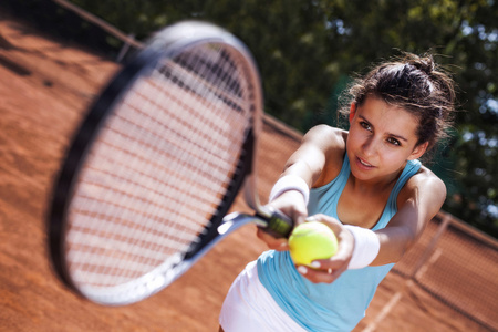捕捉一个球在网球场的年轻女孩