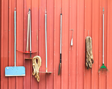 红色谷仓的墙上挂的农场工具