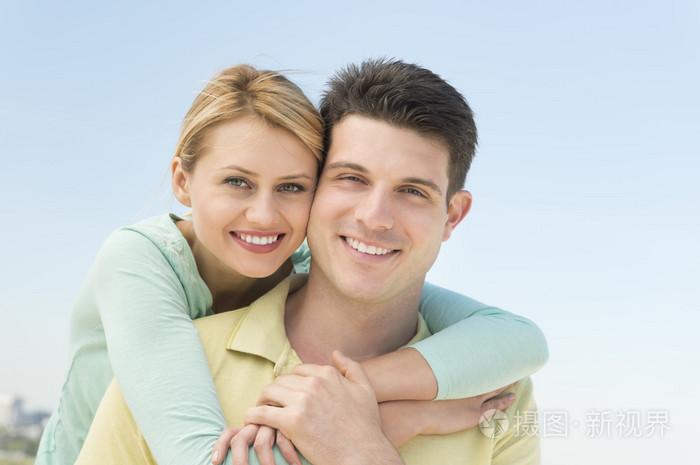 女人拥抱男人从背后打击的晴朗天空