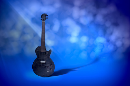 无缝蓝色抽象背景上的黑色电吉他。