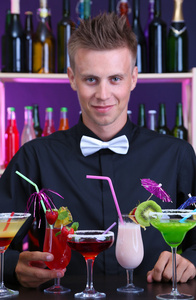 与不同的鸡尾酒鸡尾酒，在酒吧的帅哥酒保的肖像