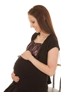 怀孕妇女持有的肚子坐看看