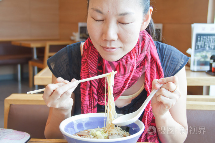年轻女子吃面条