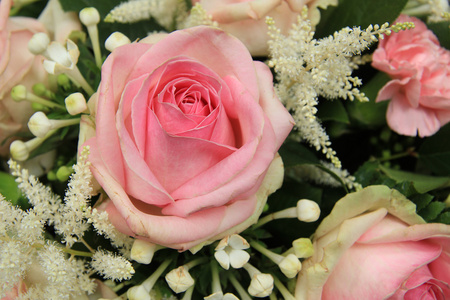 粉红玫瑰和 stephanotis 在新娘花束