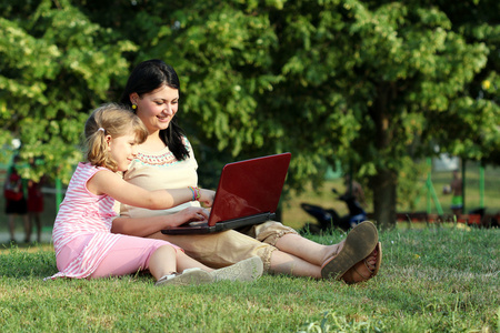 儿童和笔记本电脑在公园中的女孩
