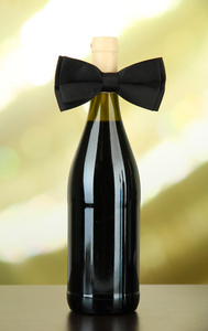 在葡萄酒瓶上明亮的背景上的黑色蝴蝶领结。