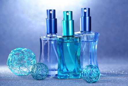 妇女在蓝色背景上的美丽瓶中的香水