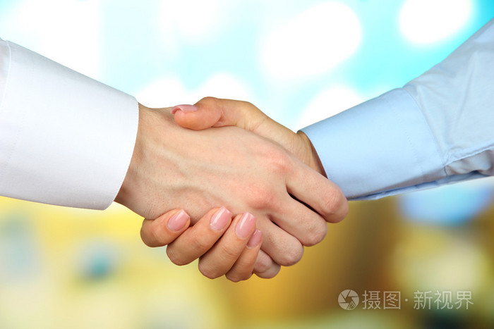 在明亮的背景上商务握手