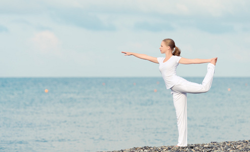 在做瑜伽在海滩上的白色女人